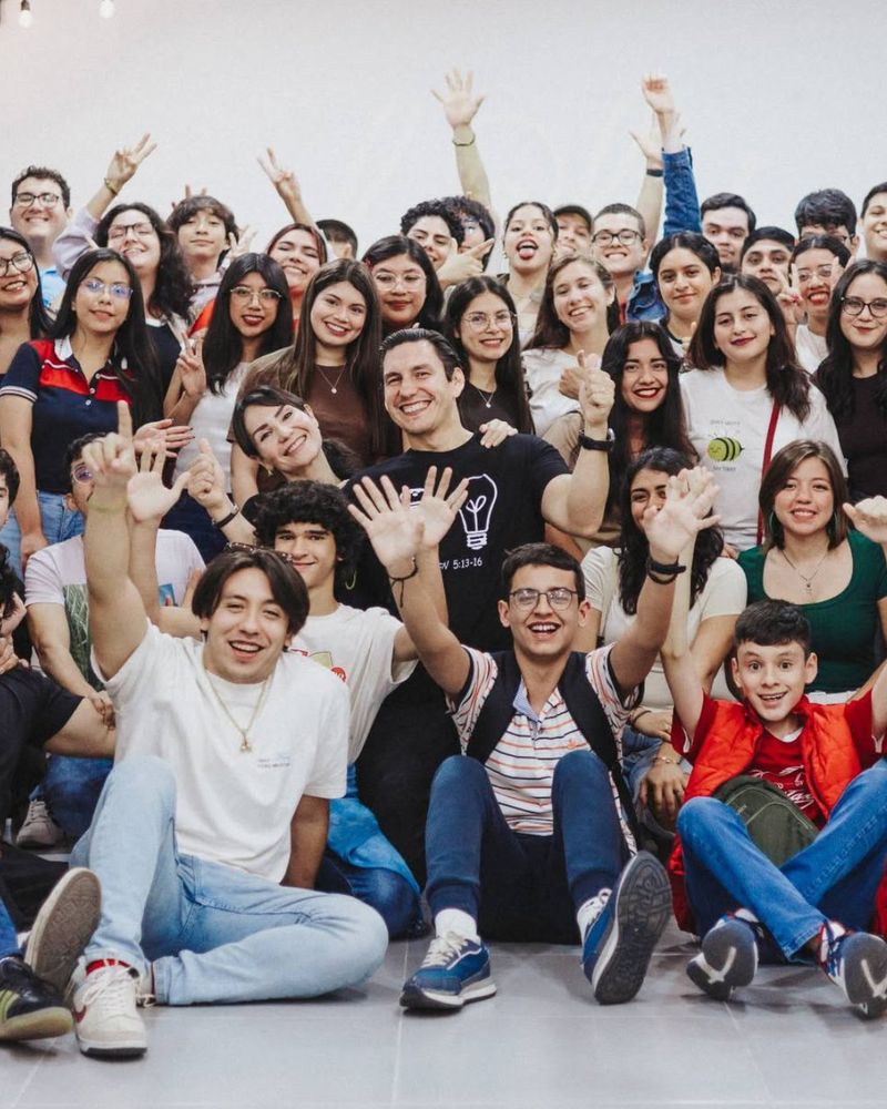 Un grupo grande de jóvenes de Light sonriendo y levantando las manos.