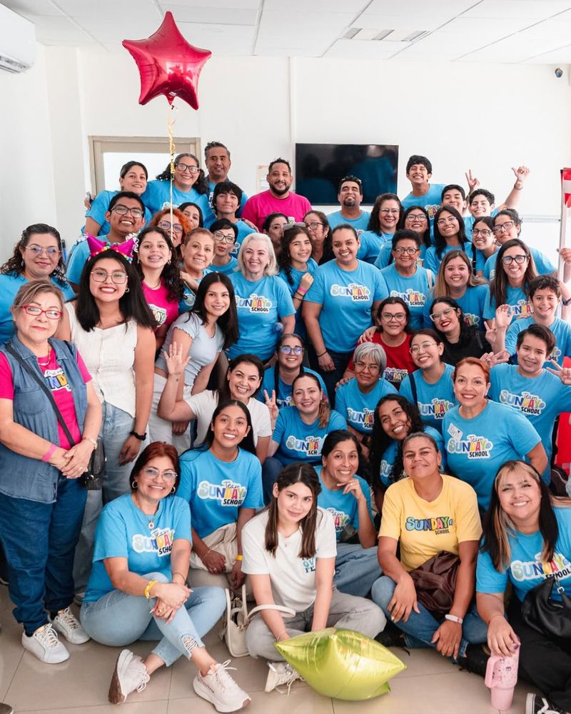 Equipo de maestros y voluntarios de Sunday School con playeras azules.